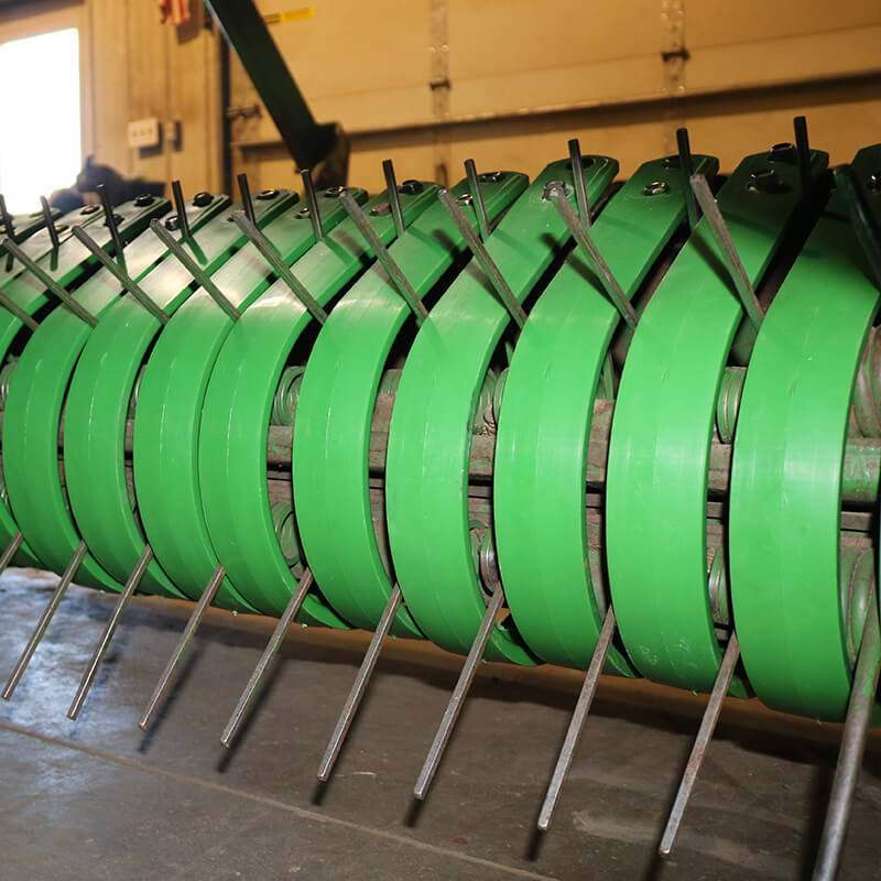 Green poly pickup bands on John Deere baler