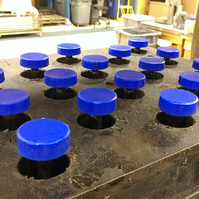 Blue poly capped bolts in the mold