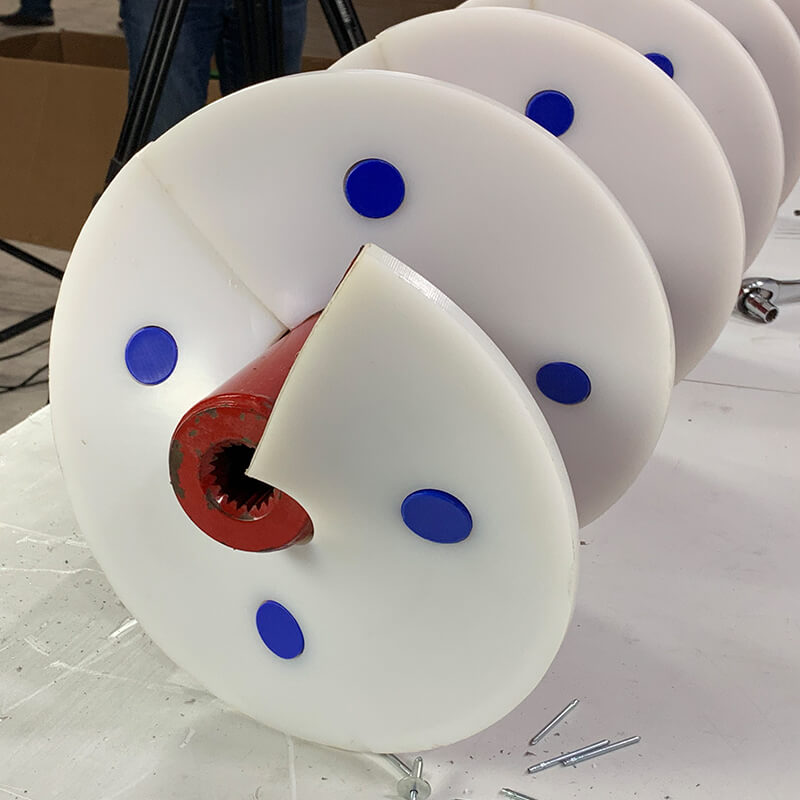 Blue poly capped bolts installed with white poly auger wearshoes for 100% poly surface on auger