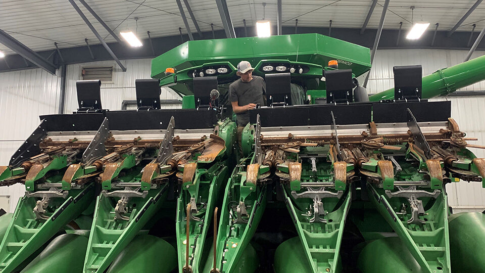 Load video: Chet Larson from Larson Farms standing on John Deere folding chopping corn head with May Wes G4 Stalk Stompers installed