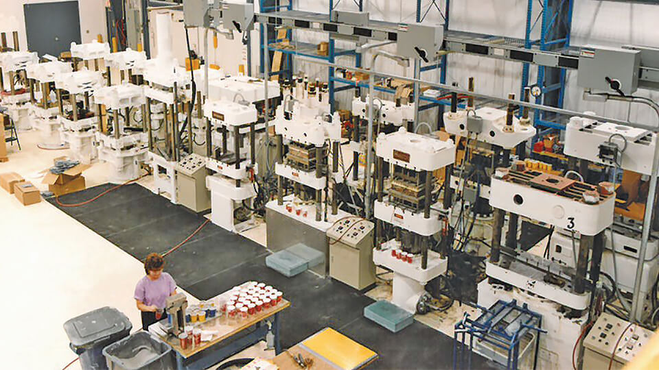 Manufacturing floor with several compression molding presses at May Wes Manufacturing