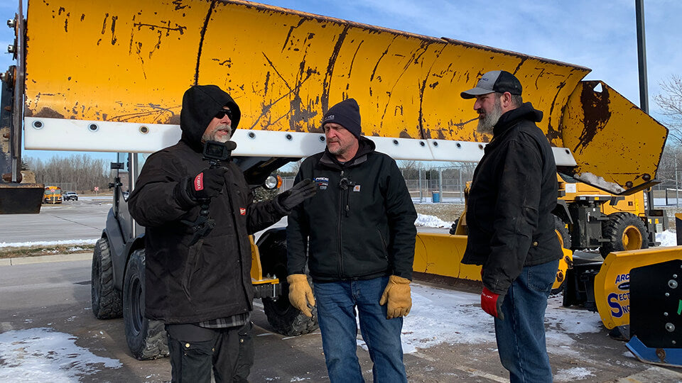 Load video: Stanley &quot;Dirt Monkey&quot; Genadek with Eric Bates and Matt Schmidt from May Wes Manufacturing standing in front of Arctic LD Sectional Snow Pusher with May Wes Poly Cutting Edge installed