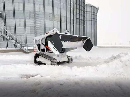 plowing snow with Bobcat snow pusher at Larson Farms