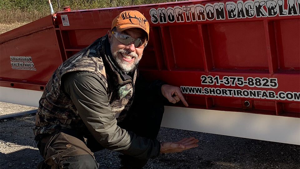 Load video: Stanley &quot;Dirt Monkey&quot; pointing at white May Wes Poly Cutting Edge installed on Short Iron back plow and smiling